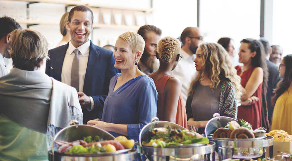 smiling happy people at food event with buffet table fruits salad in metal bowls in front of them community diverse lifestyle events at nmi