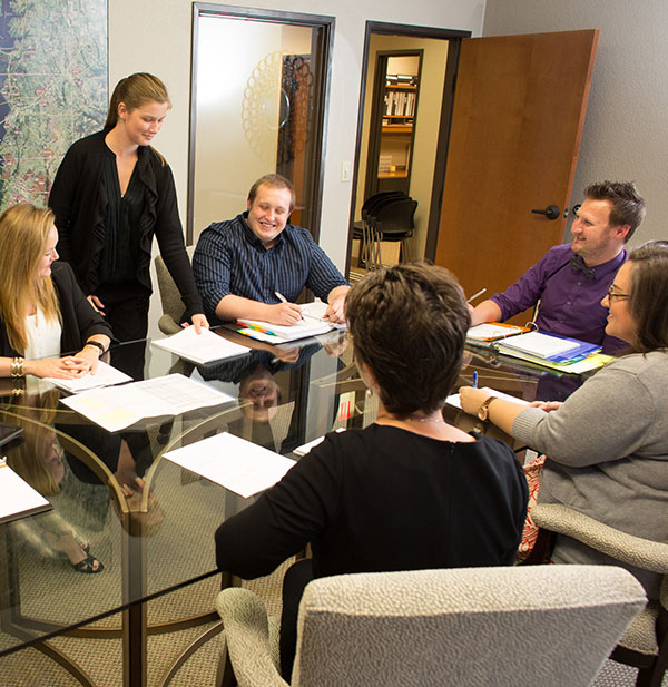 Neighborhood Management team at conference table happy smiling and planning