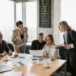 HOA board members and mediators discussing documents during a community dispute resolution meeting.