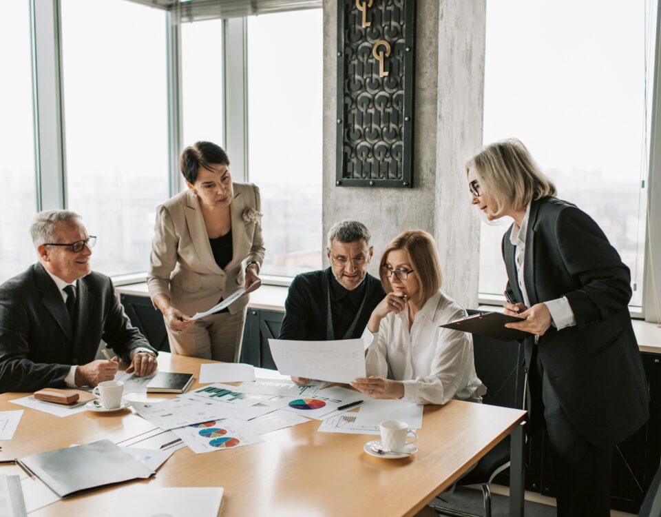 HOA board members and mediators discussing documents during a community dispute resolution meeting.
