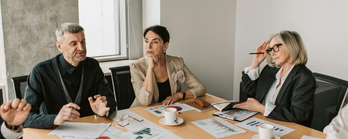 HOA board members discussing reports with management professionals during a meeting.