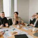 HOA board members discussing reports with management professionals during a meeting.