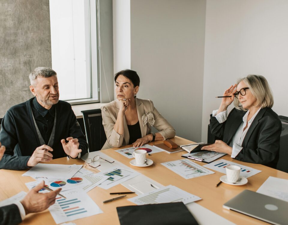 HOA board members discussing reports with management professionals during a meeting.