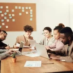 Group of professionals collaborating in a meeting to discuss community engagement strategies.