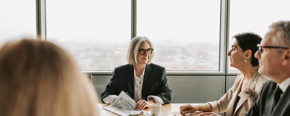 HOA board members meeting with a management company representative in a conference room.